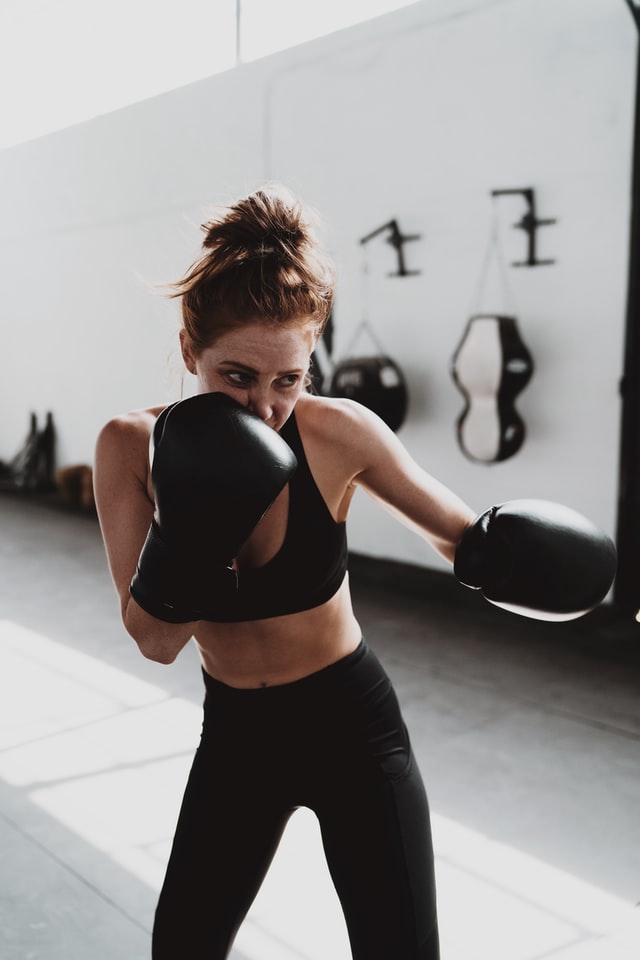 Female in black boxing gear practicing her boxing form.
